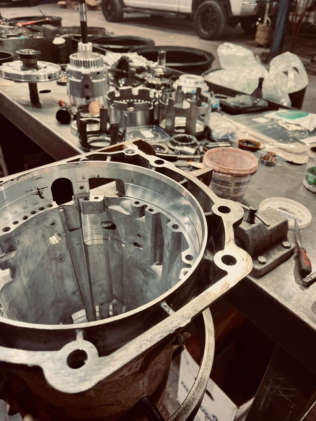 A bunch of metal parts are sitting on a table in a garage.