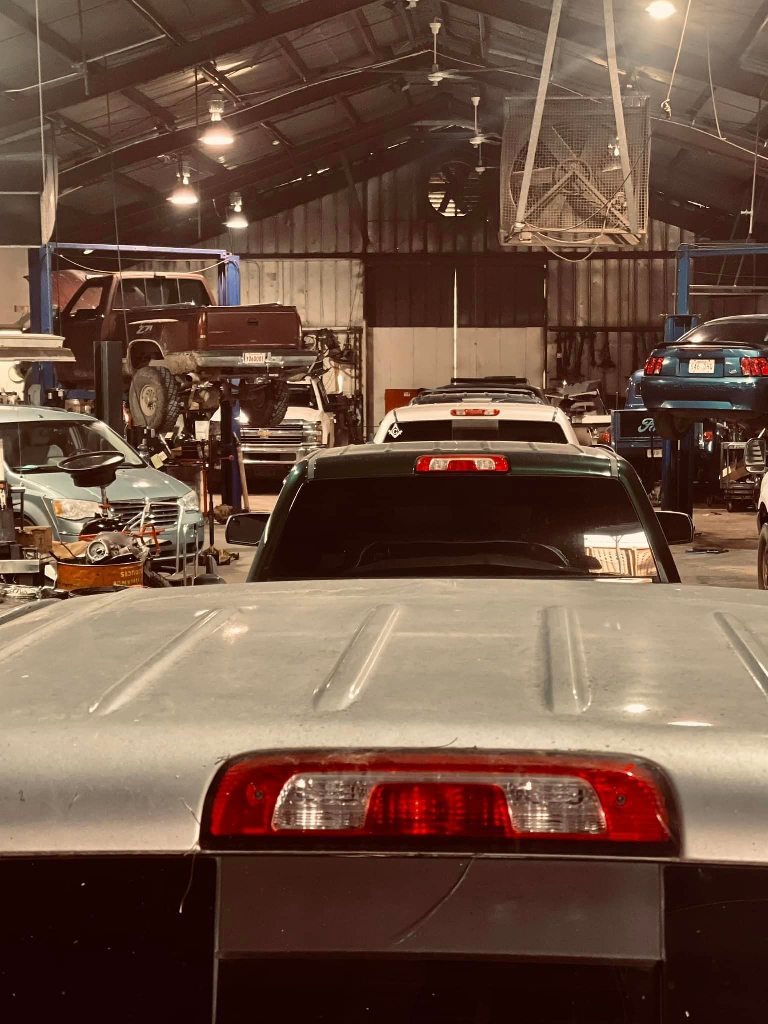 A row of cars are parked in a garage.