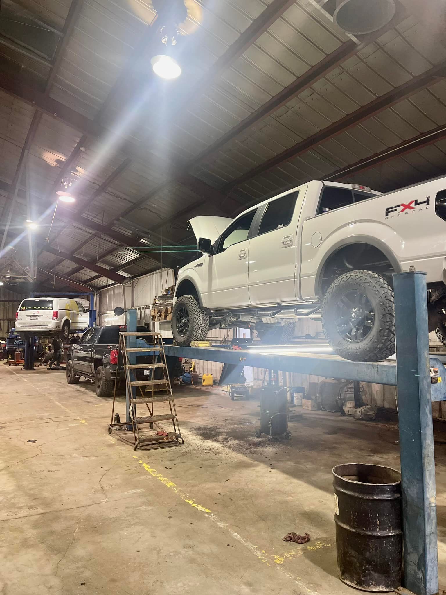 A truck is sitting on a lift in a garage.