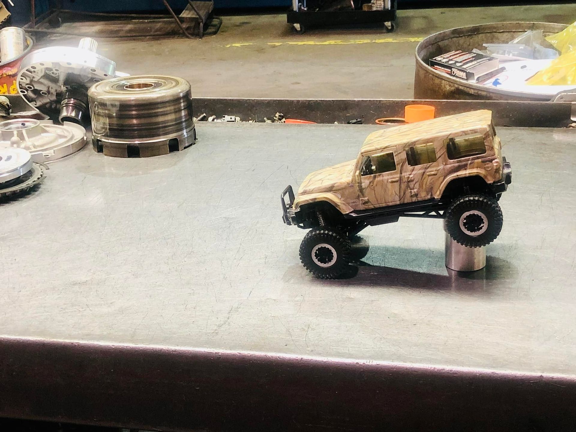 A toy jeep is sitting on top of a metal table.