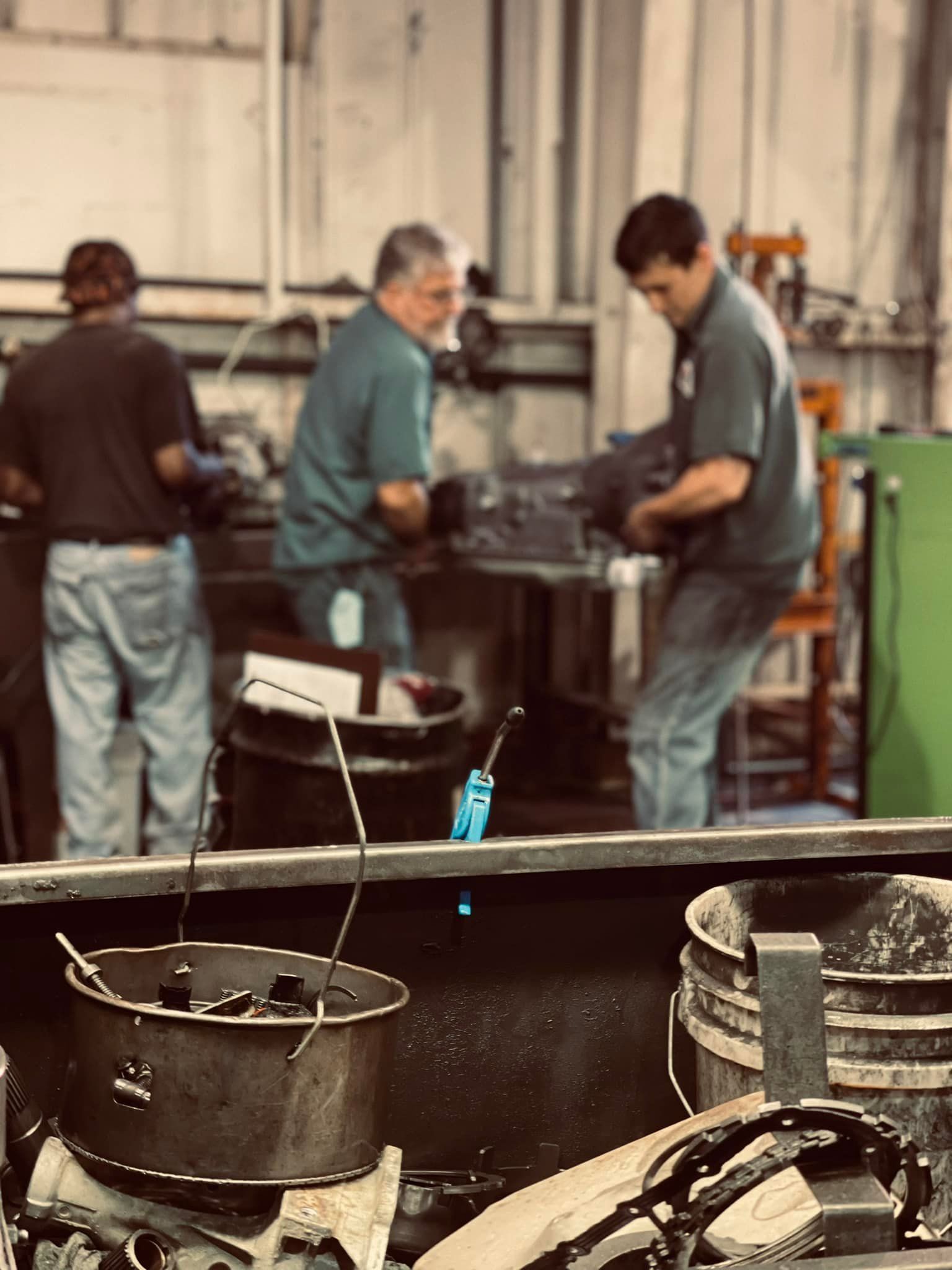 A group of men are working on a machine in a factory.