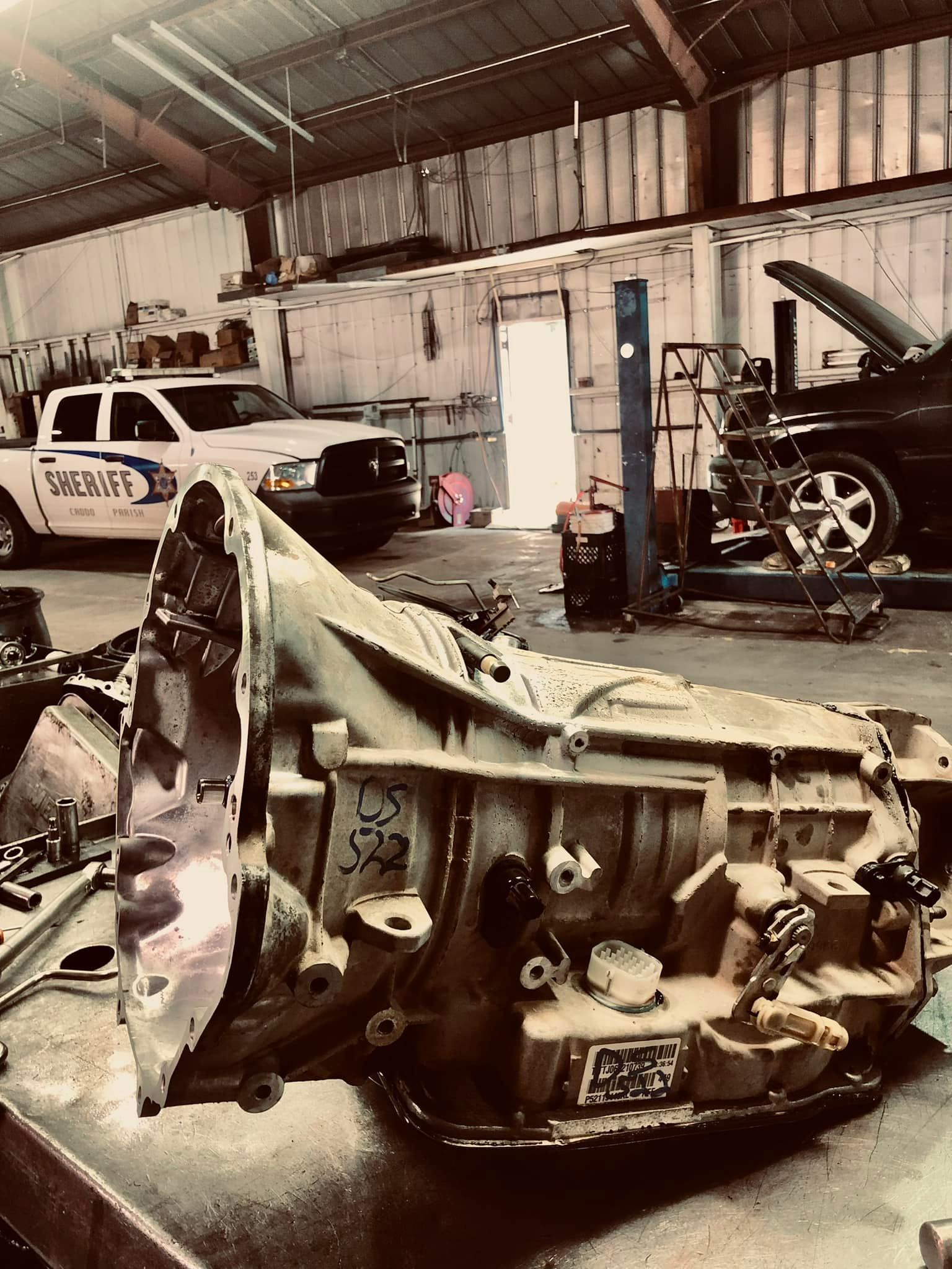 A car engine is sitting on a table in a garage.