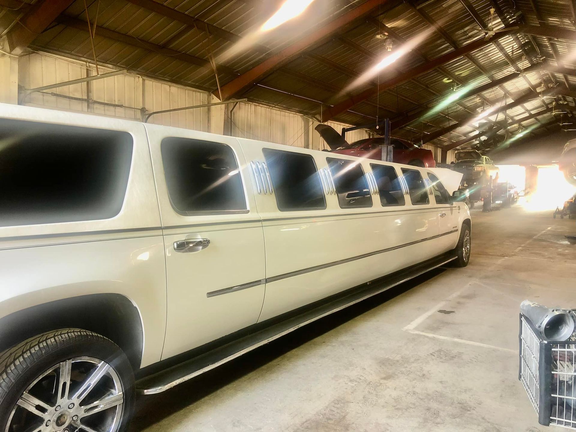 A long white limousine is parked in a garage.