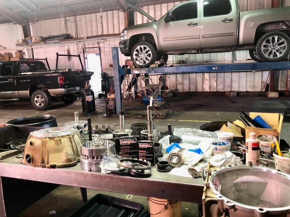 A truck is sitting on top of a lift in a garage.
