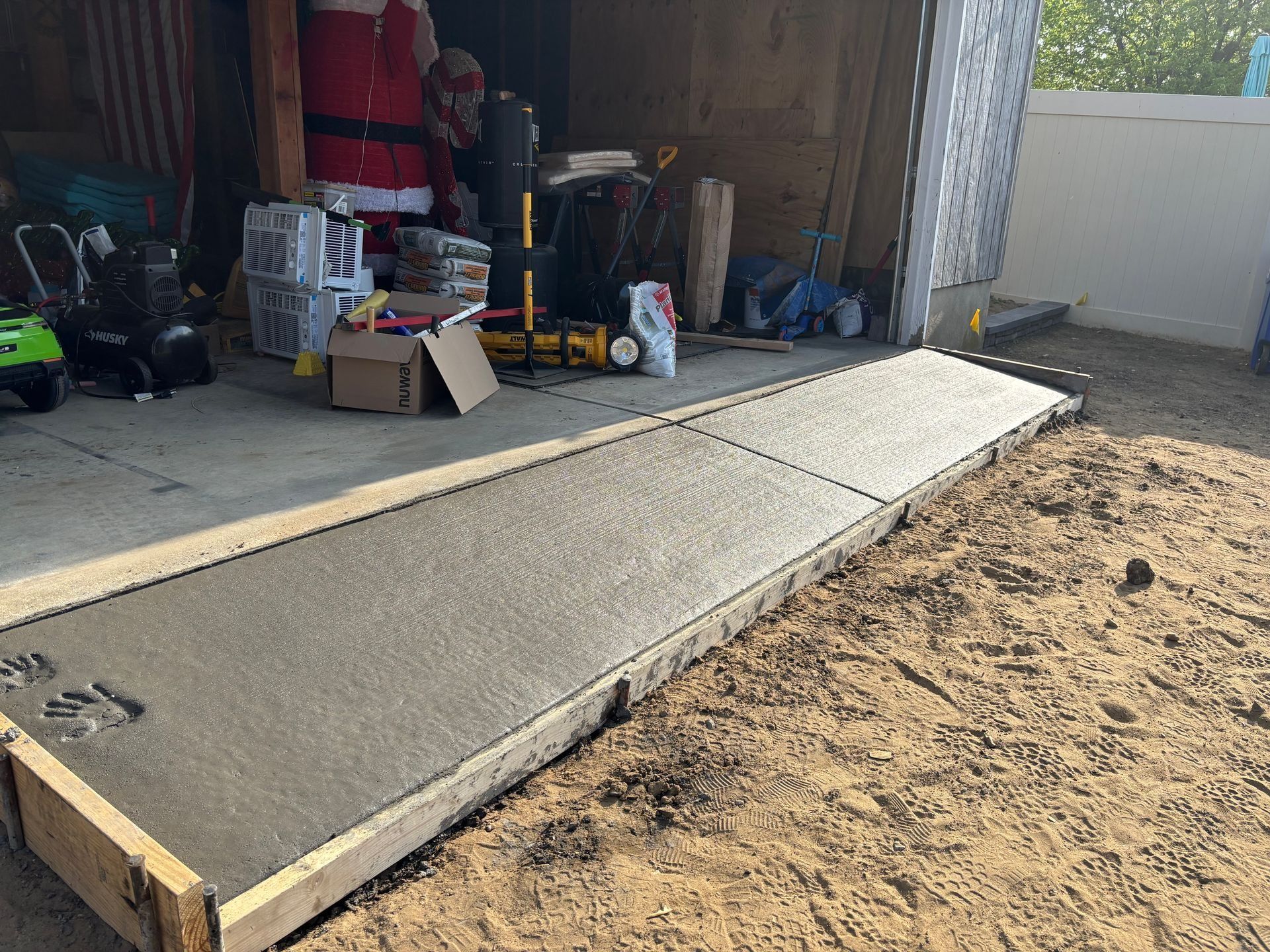 Newly poured concrete ramp leading up to a garage.