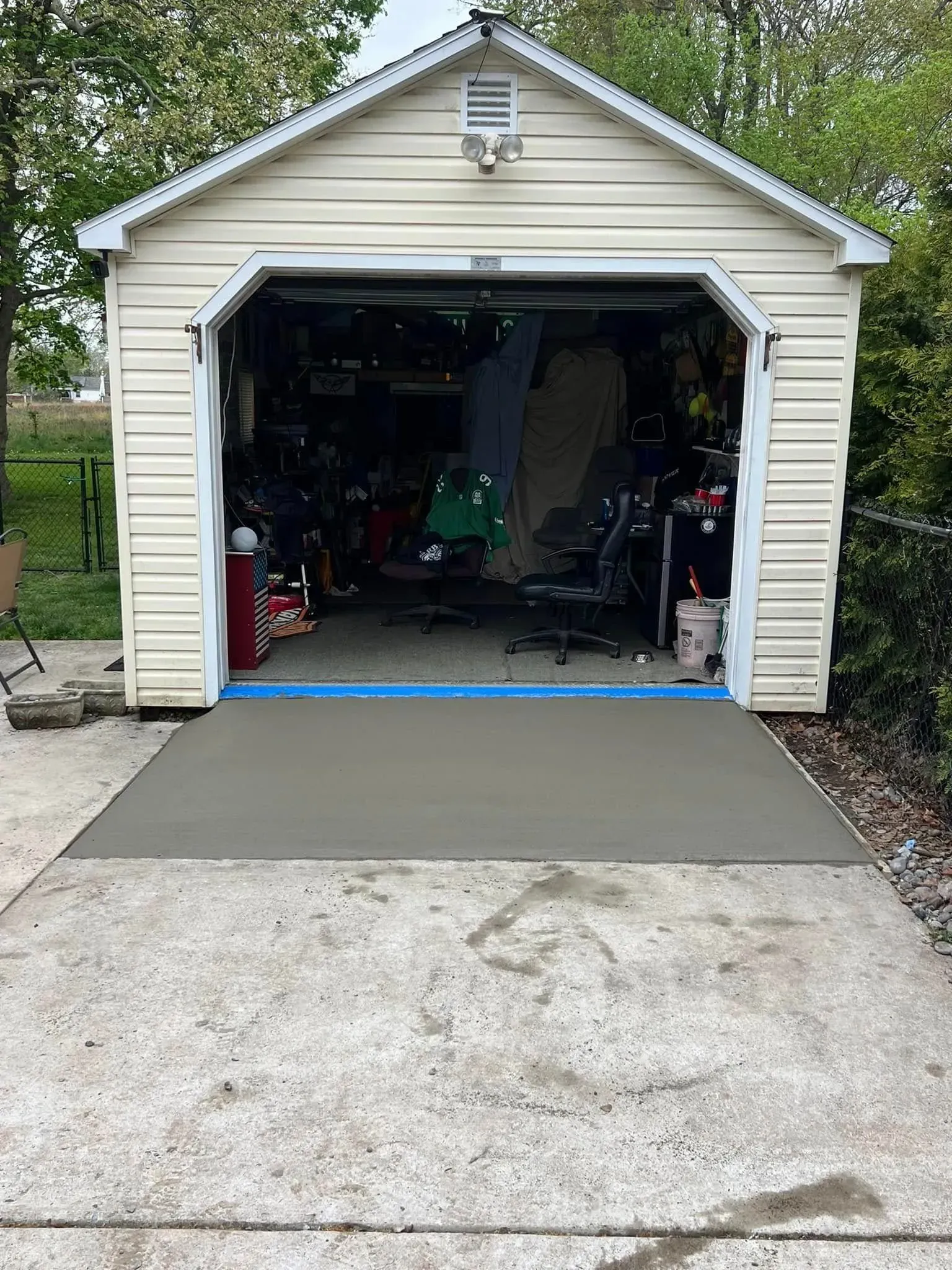 New concrete garage ramp in front of a garage with an open door.