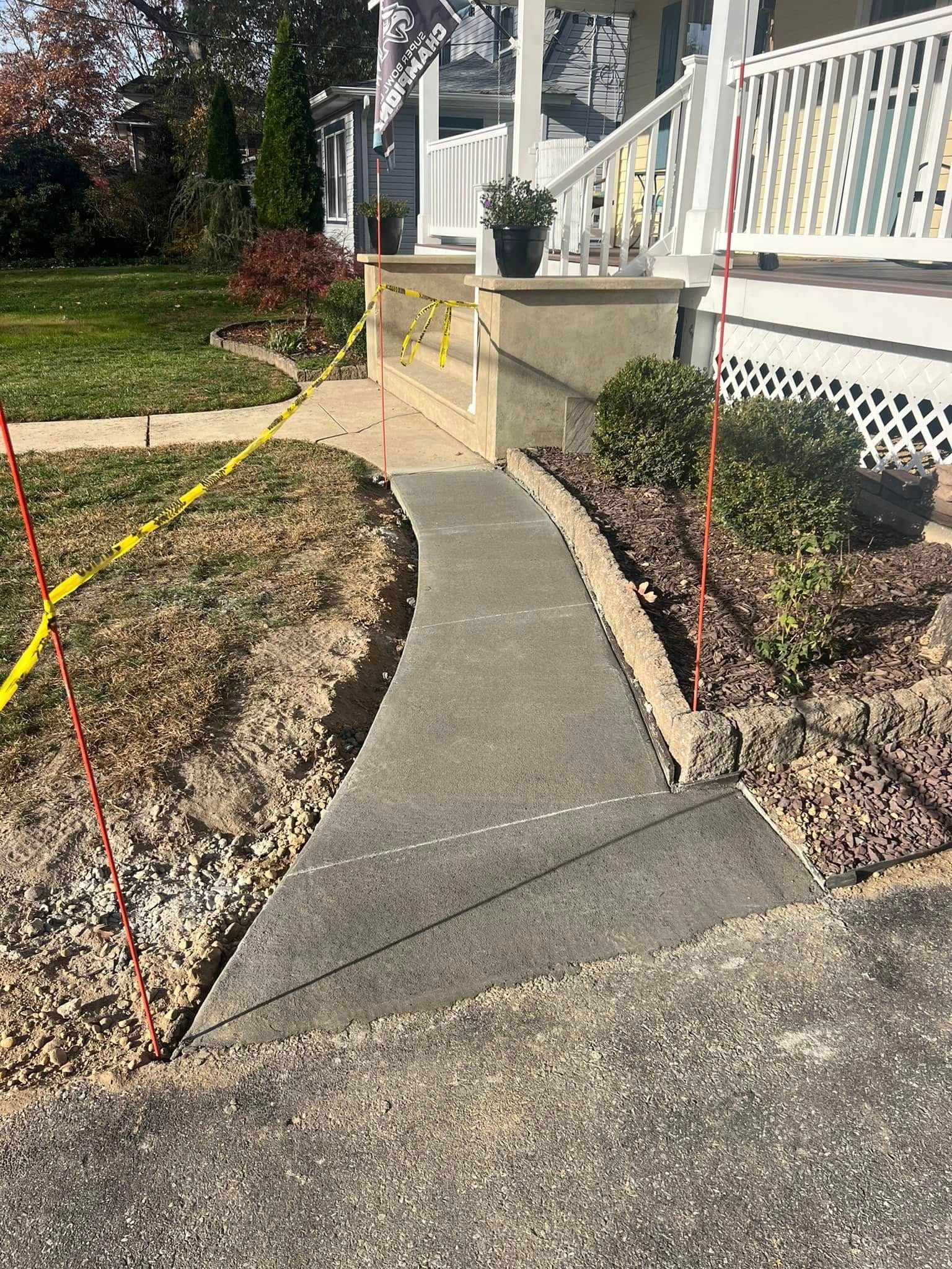 A concrete pathway leading to a house front porch. Red and yellow markers outline the path.