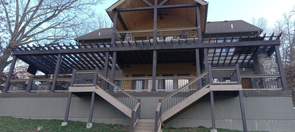 A large house with a large deck and stairs leading up to it
