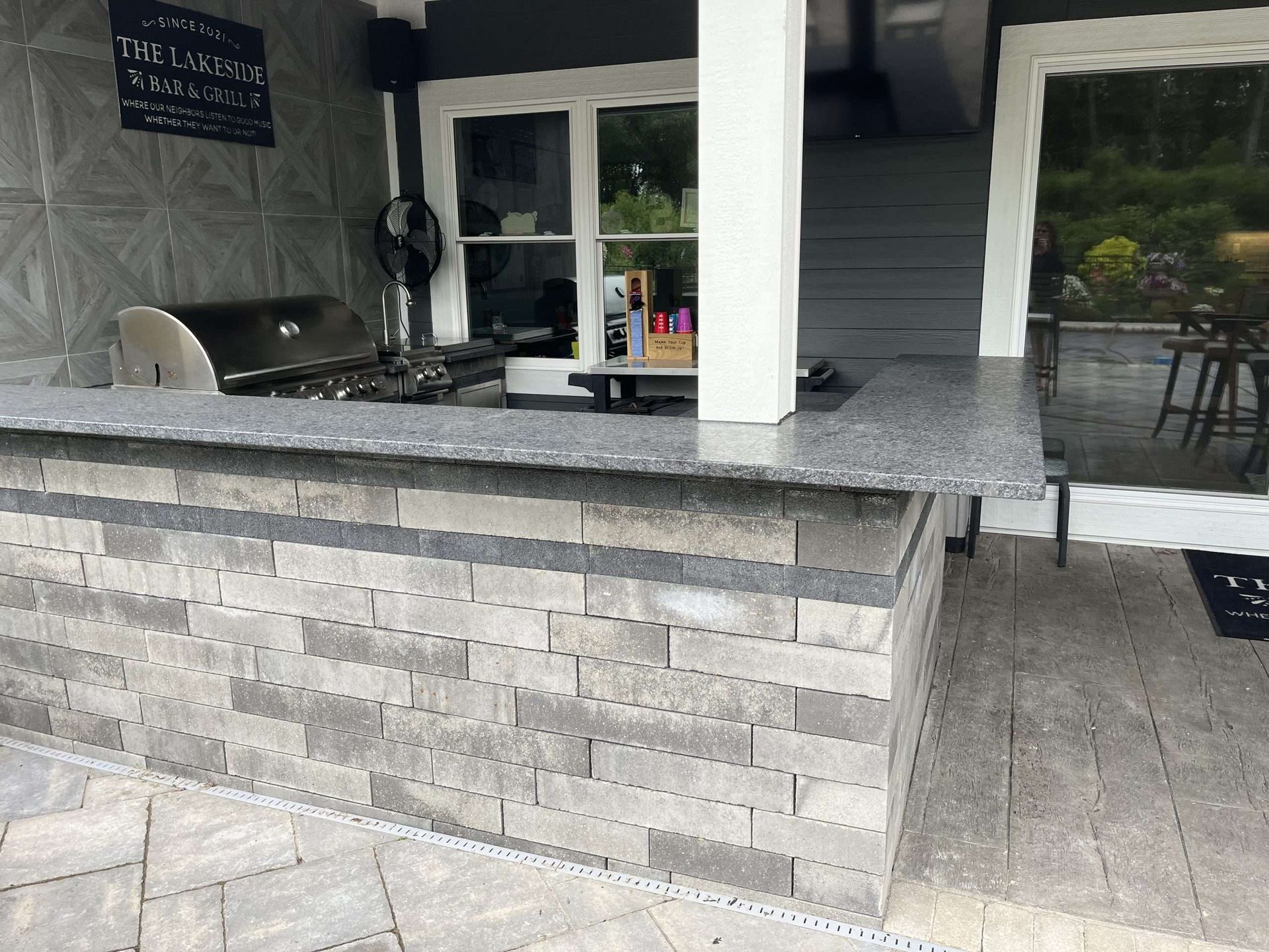 A kitchen with a brick countertop and a grill.