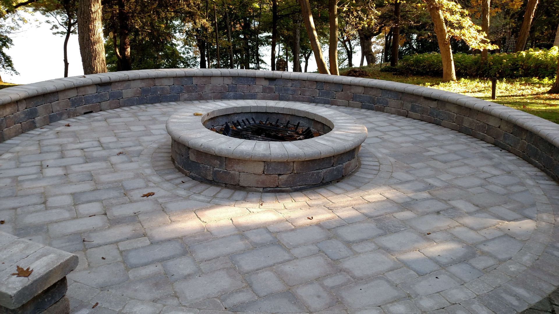 A fire pit in the middle of a brick patio.