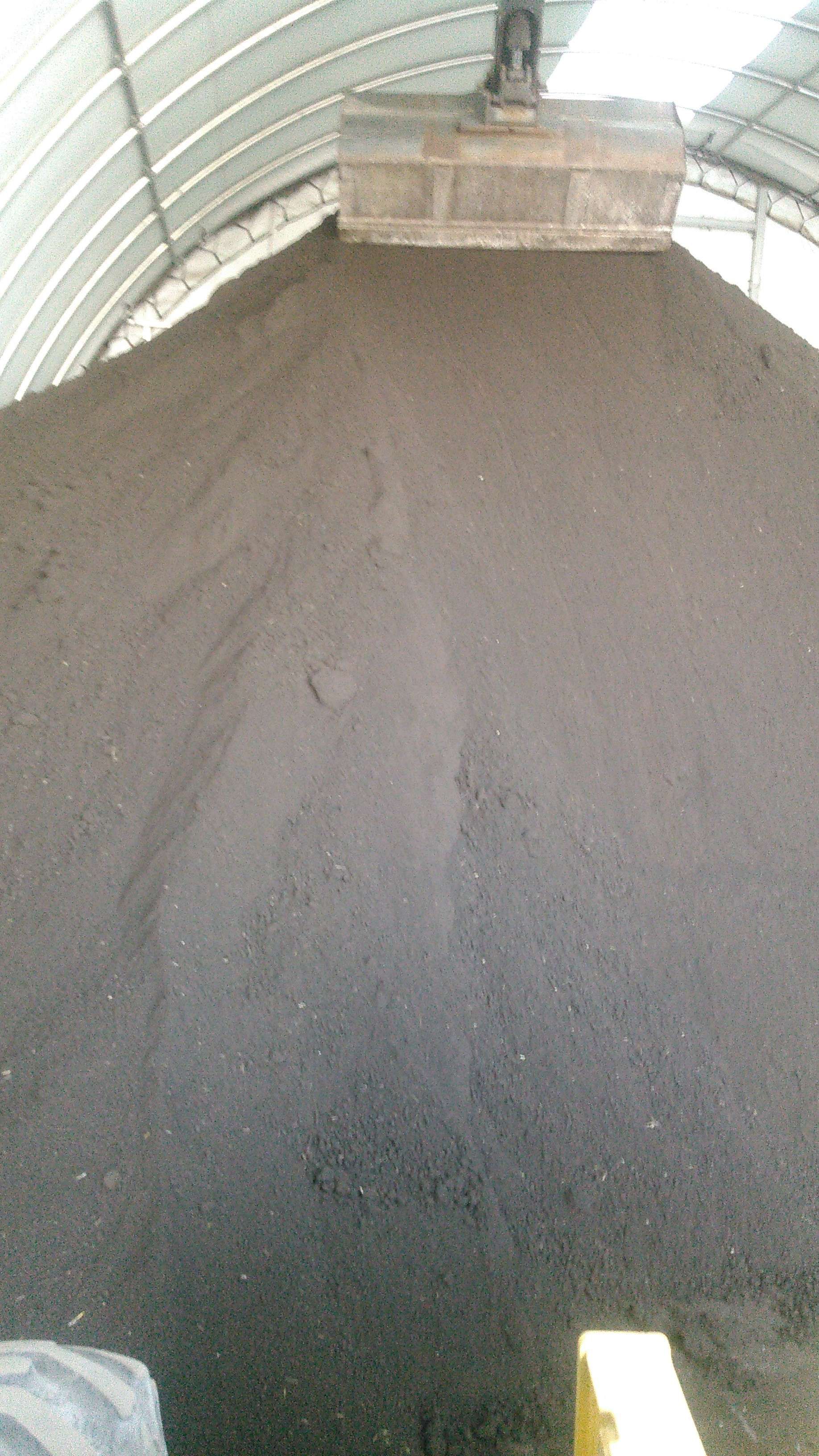 A large pile of dirt is sitting inside of a building.