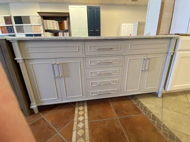 Light gray bathroom vanity with silver hardware. Tile floor.