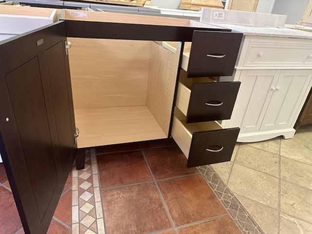 Brown bathroom vanity with open door and drawers. Interior shows natural wood.