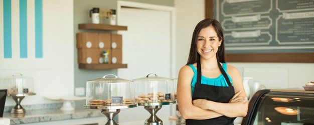 portrait of a beautiful young business owner standing in front of her bakery and smiling
