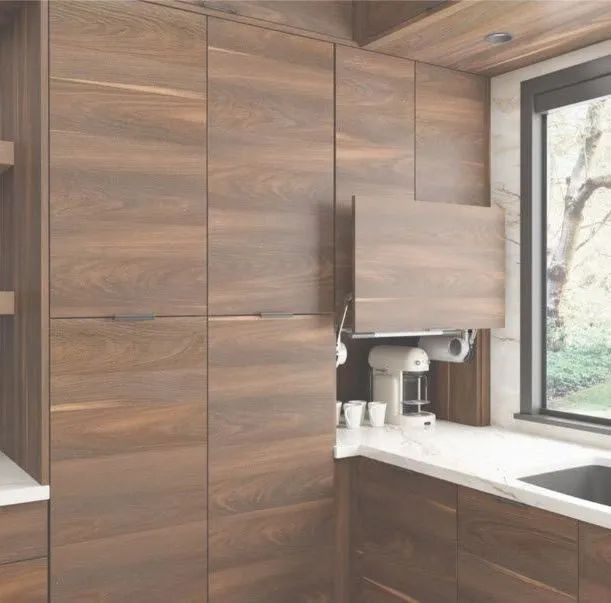 Modern kitchen with wood cabinets, white countertop, and a sink beside a large window