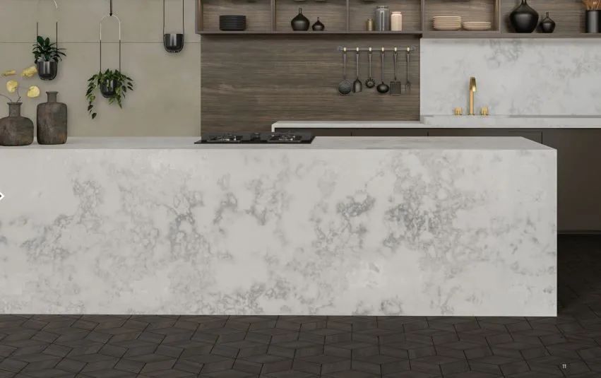 Modern kitchen with a large white marble island, wood backsplash, hanging utensils, and dark floor tiles