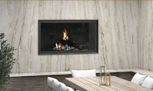 Modern patio with a lit wall fireplace, stone table, and white cushioned seating