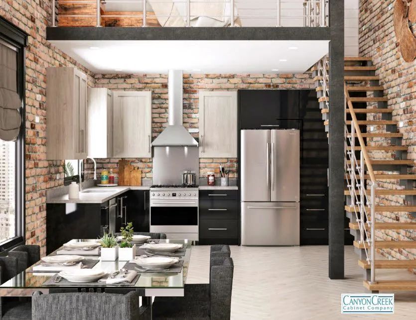 Loft kitchen with exposed brick, stainless appliances, and a dining table beneath a mezzanine