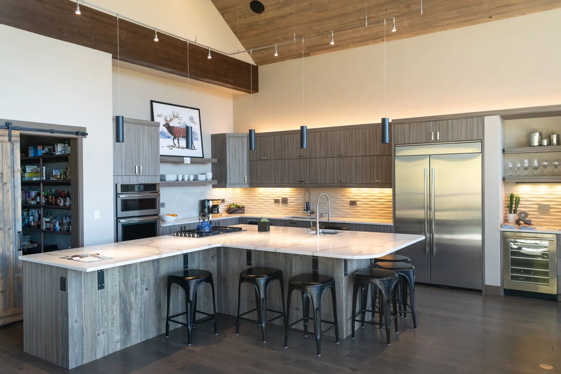 Modern kitchen with stainless steel appliances, dark wood cabinets, island, and bar stools