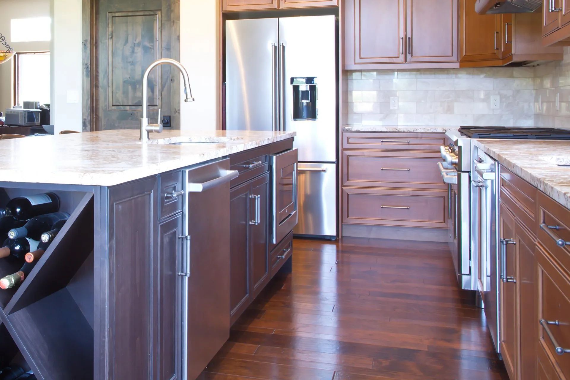 Modern kitchen with island, stainless steel fridge, dark wood cabinets, and hardwood floors