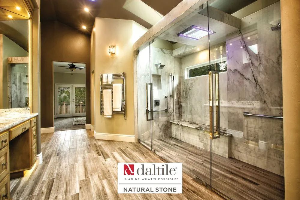 Modern bathroom showroom with wood-look floor, glass shower, marble walls, and sink vanity