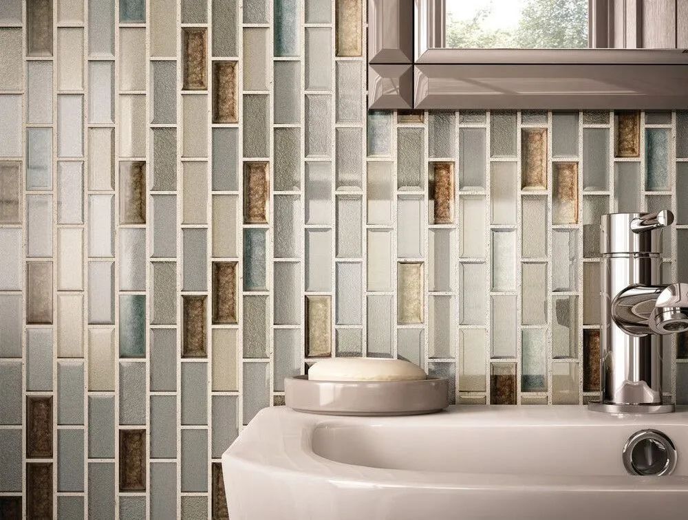 Modern bathroom sink with chrome faucet against a light blue and beige tile wall.
