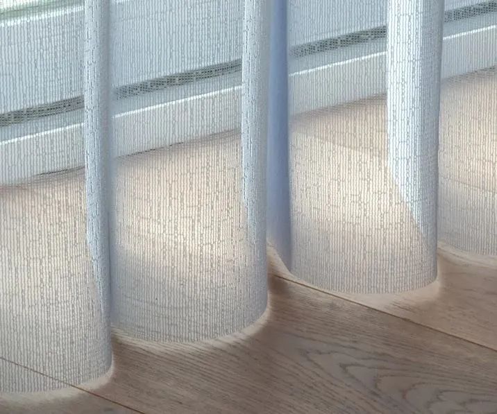 Sheer white curtains with blue vertical supports above a light wood floor.