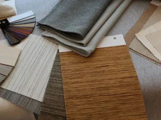 Fabric and material swatches in gray, white, brown, and beige arranged in overlapping samples.