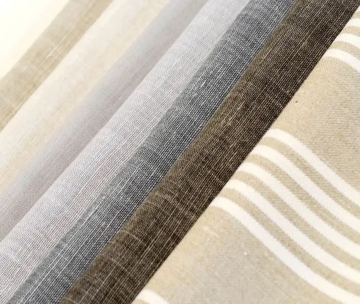 Close-up of folded fabric swatches in beige, gray, and striped patterns.