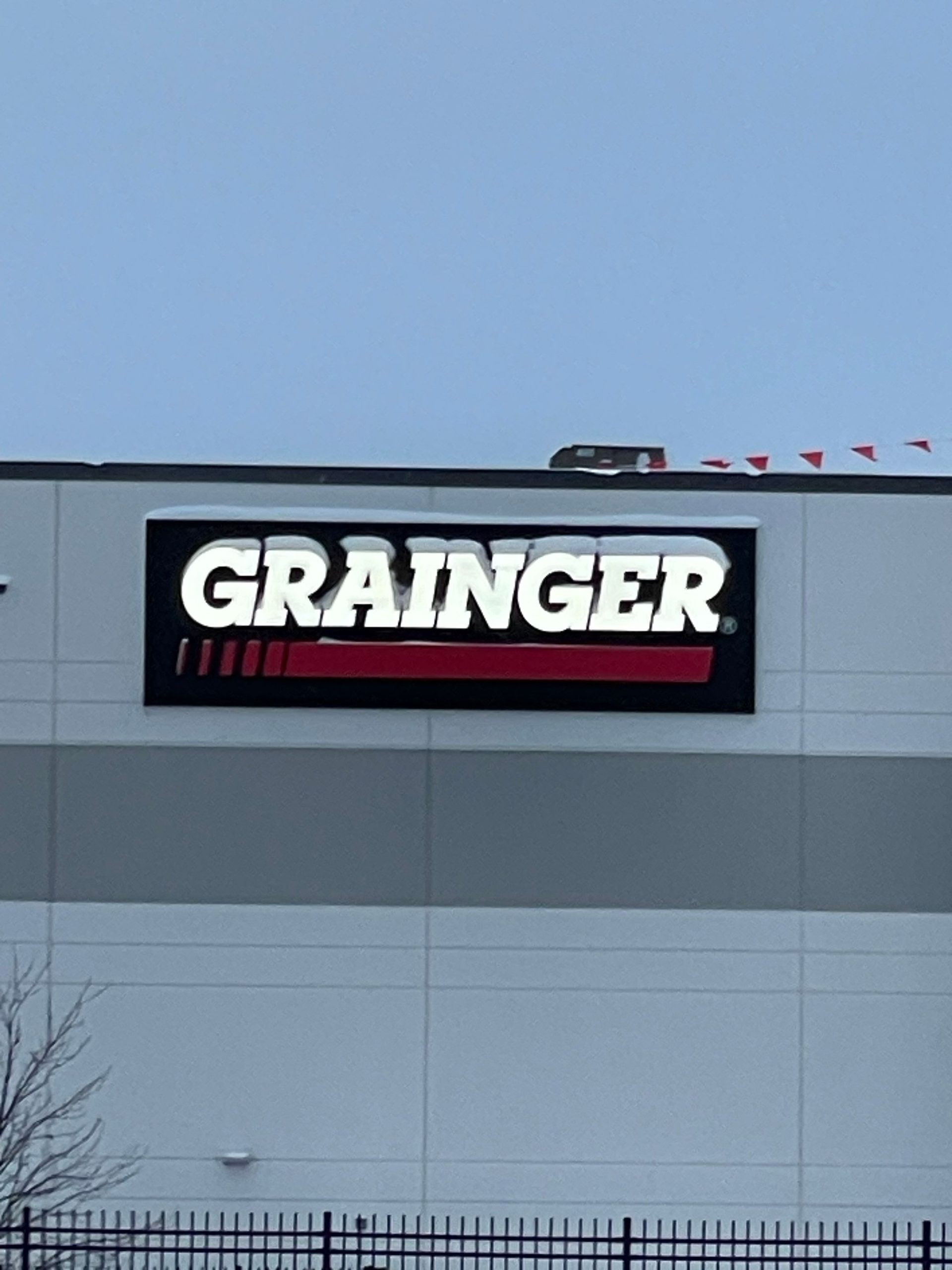 Grainger store sign on a gray building under a blue sky