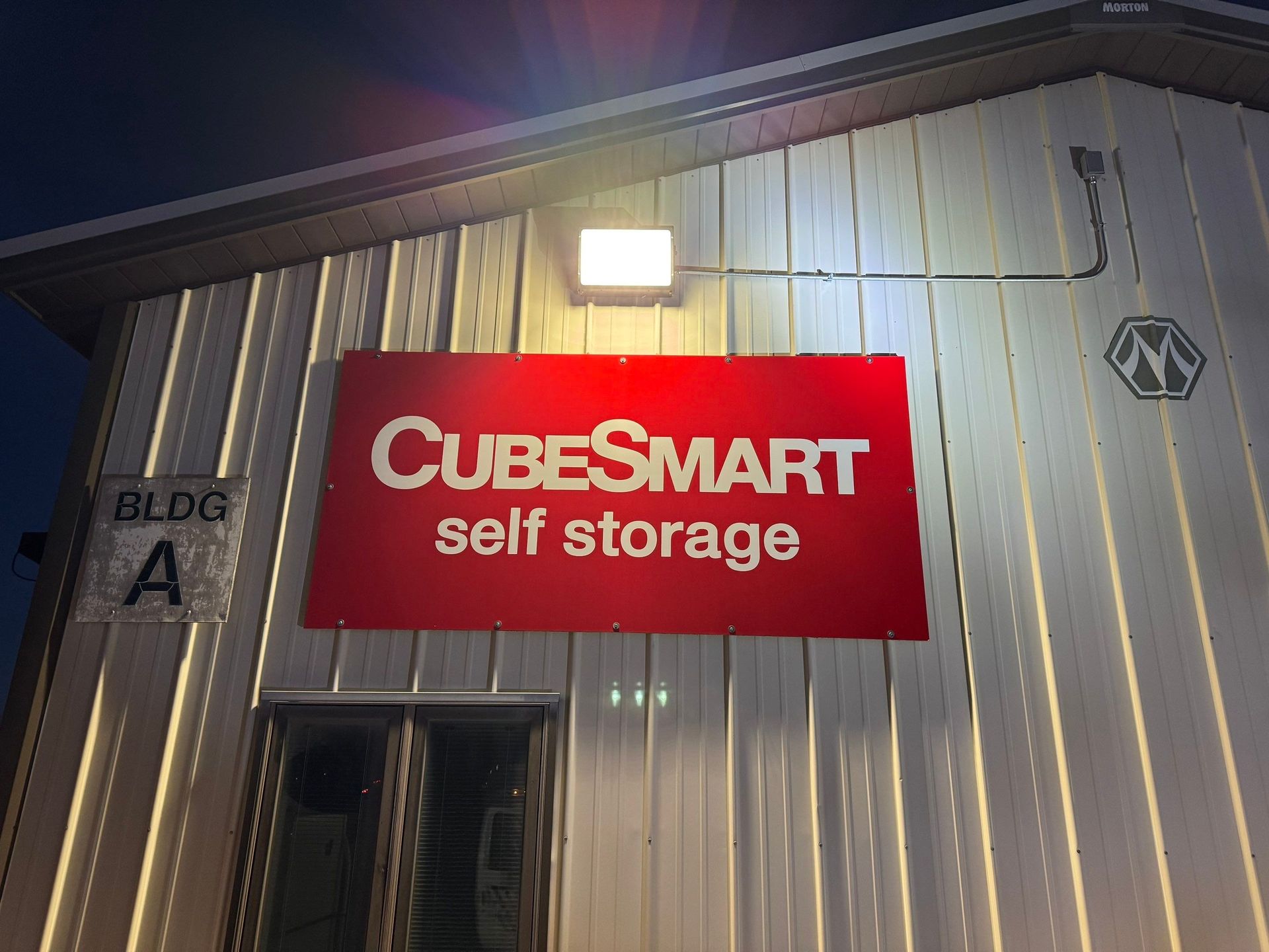 CubeSmart self storage sign on a corrugated metal building at night