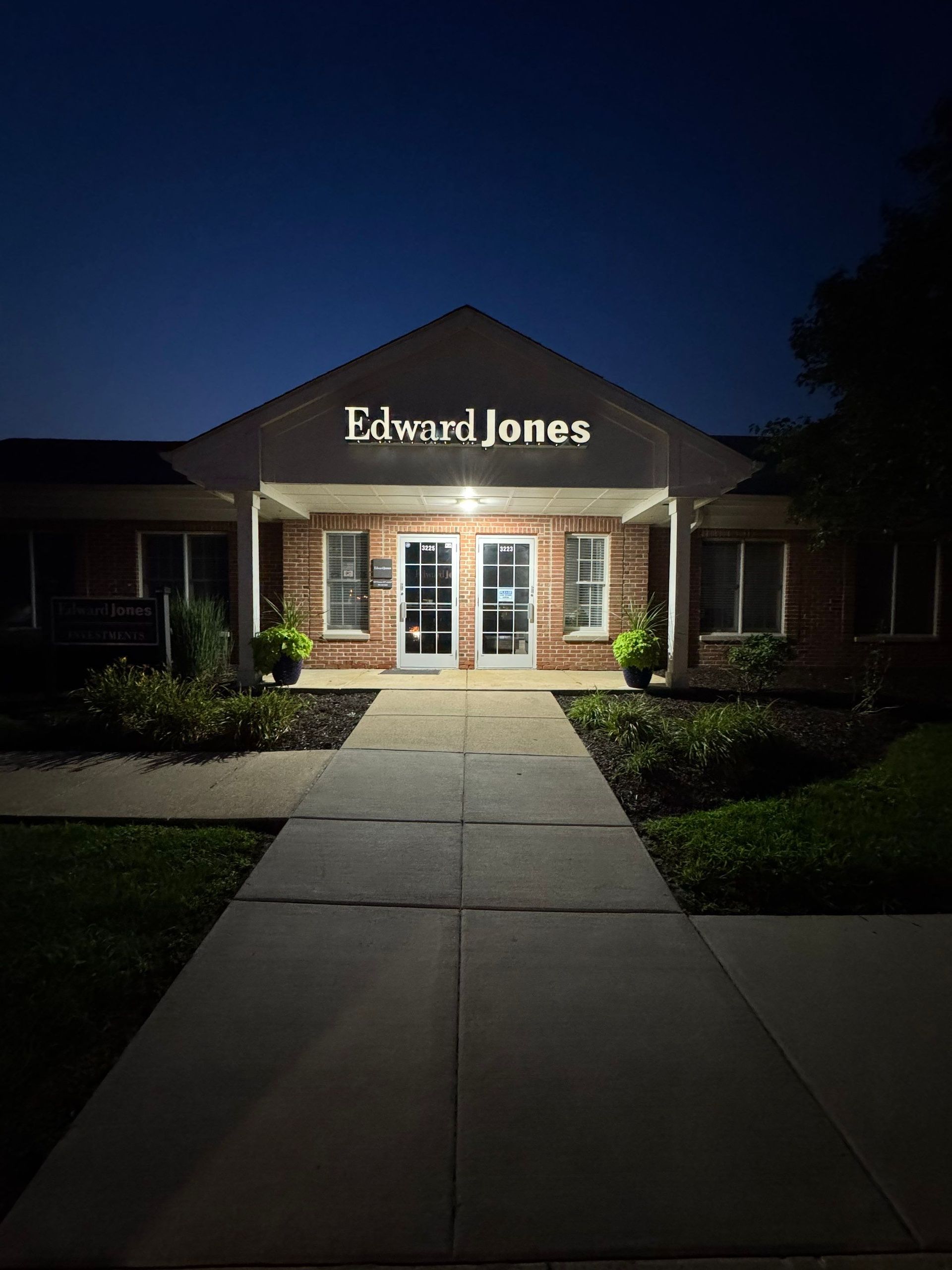 Edward Jones office building at night, lit entrance with walkway leading to the doors
