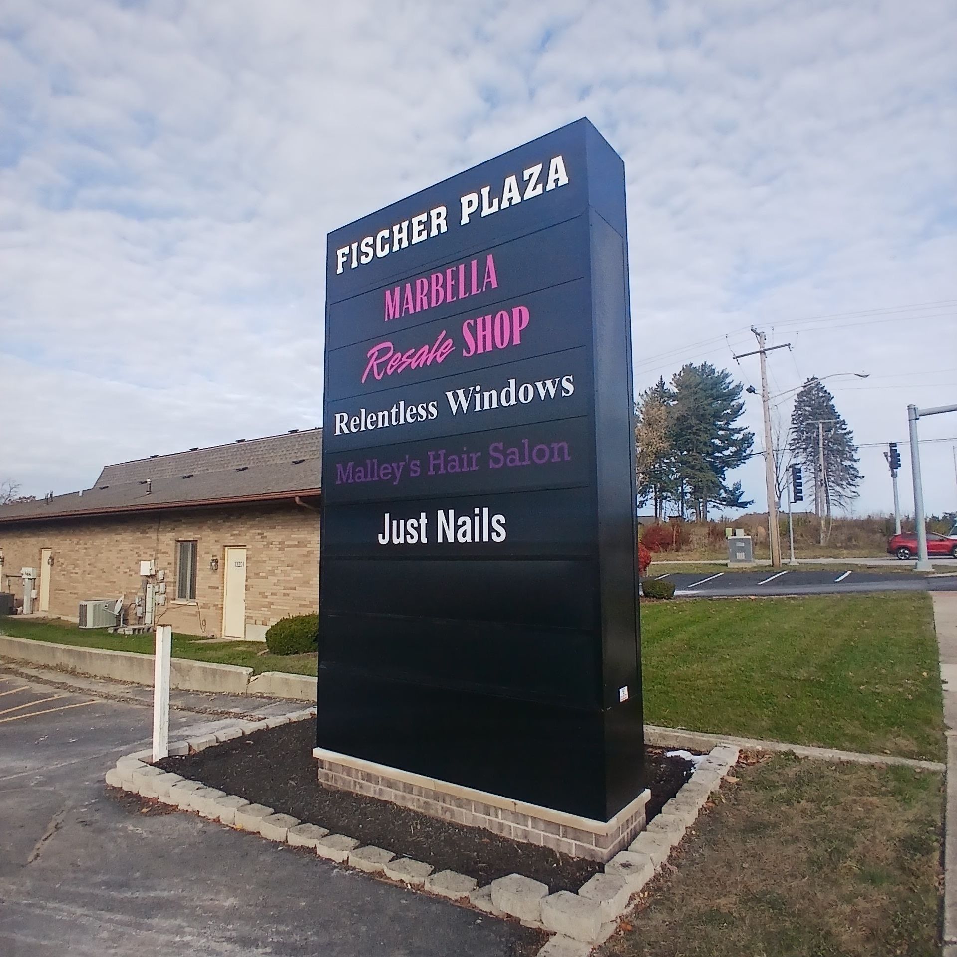 Fisher Plaza sign listing businesses, including Whitehall Beauty Shop, Restless Windows, and Just Nails.