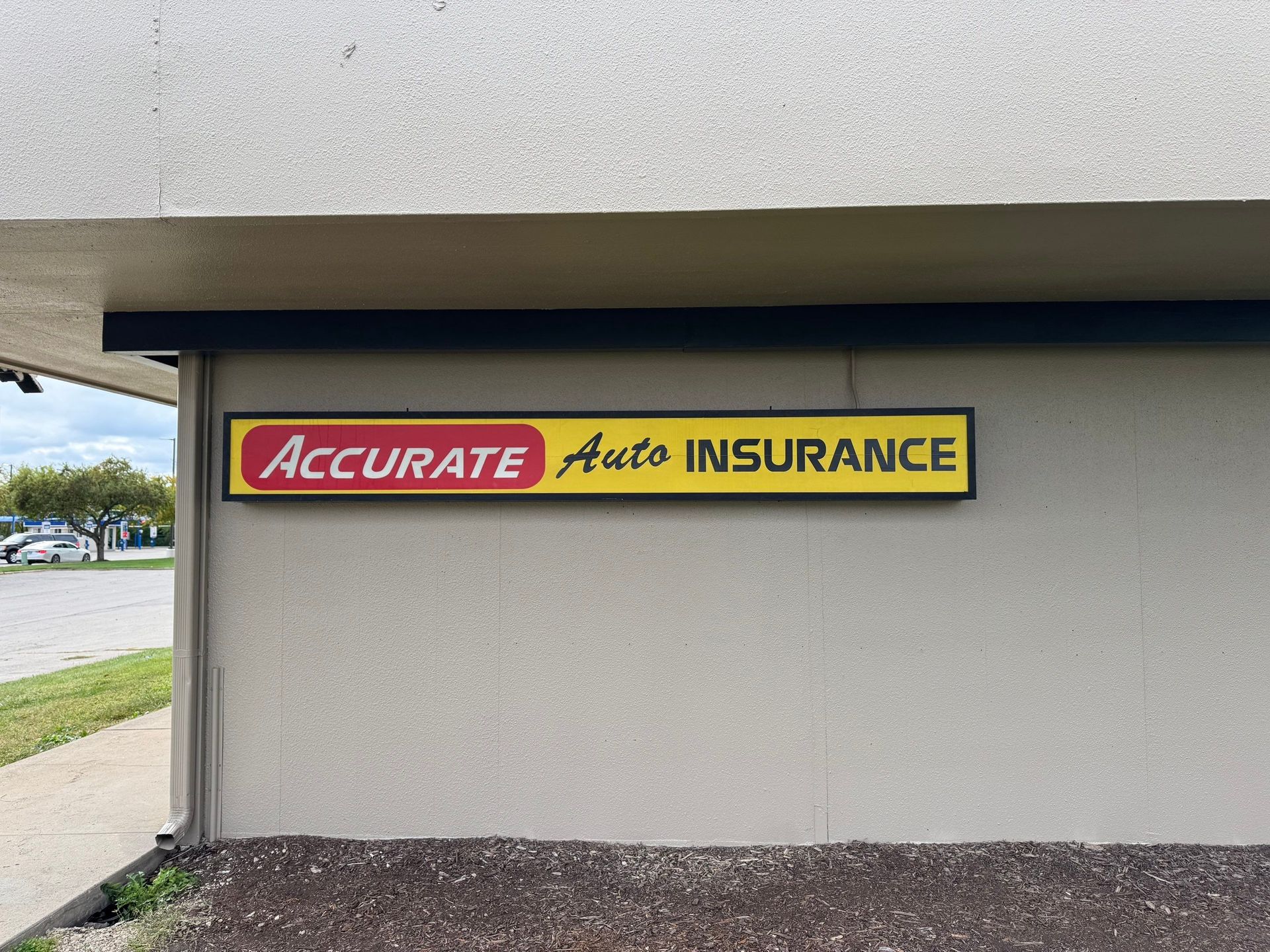Accurate Auto Insurance sign on a beige building exterior