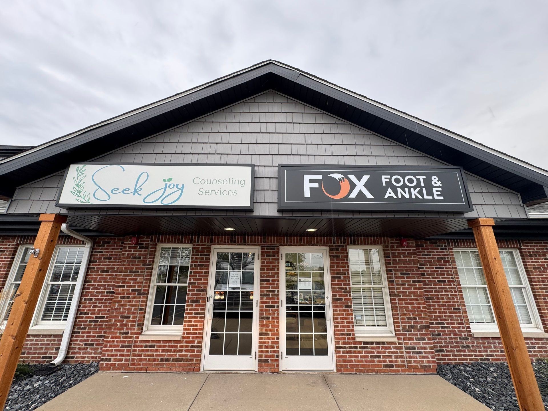 Exterior of a brick storefront with signs for Fox Foot & Ankle and a second clinic