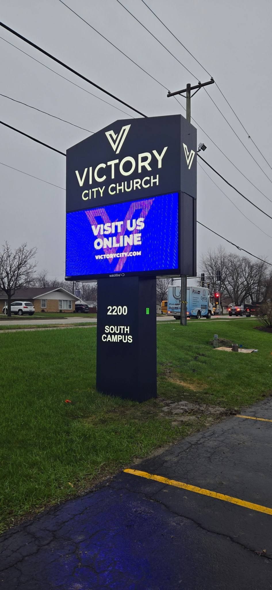 Victory Church roadside sign with blue digital message screen on a rainy day