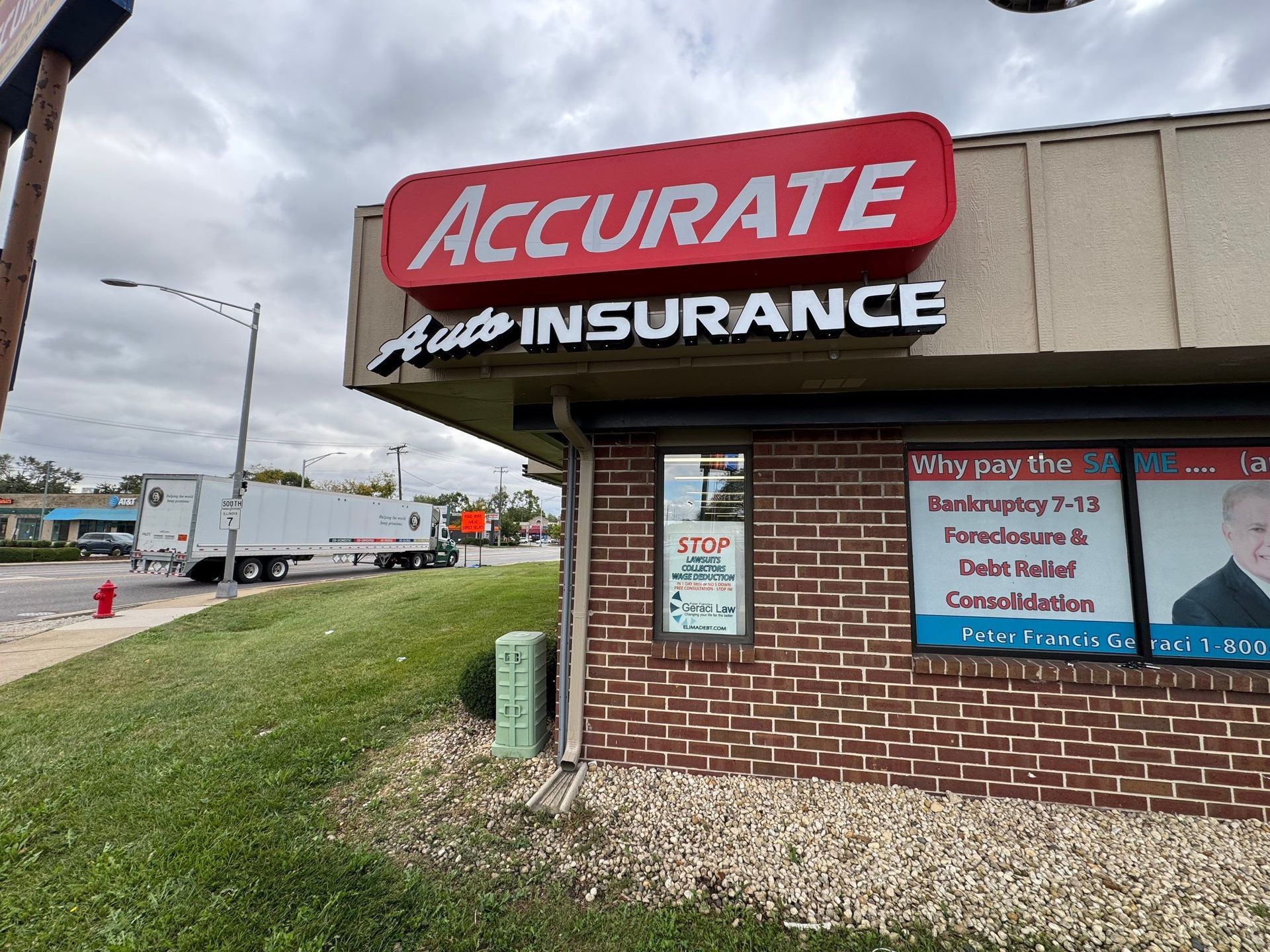 Accurate Insurance storefront with red sign on a brick building beside a roadside.