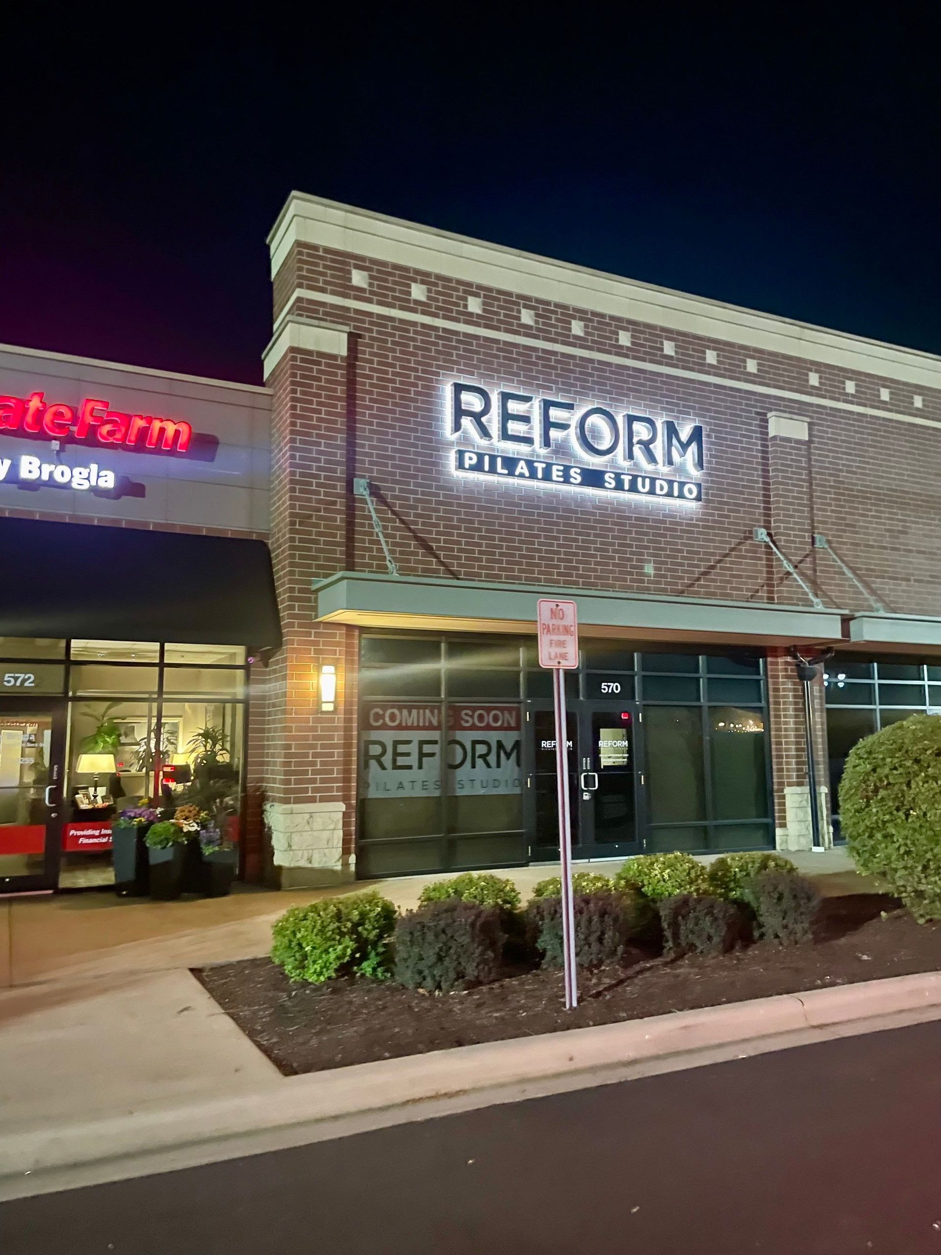 Reform House of Pizza storefront at night with brick facade and lit signage