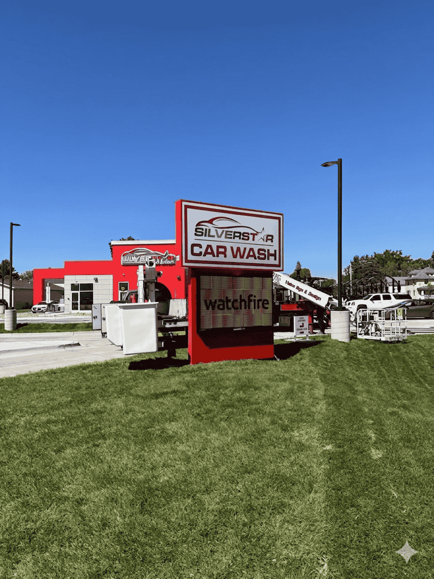 Car wash sign and building beside a grassy lot under a clear blue sky