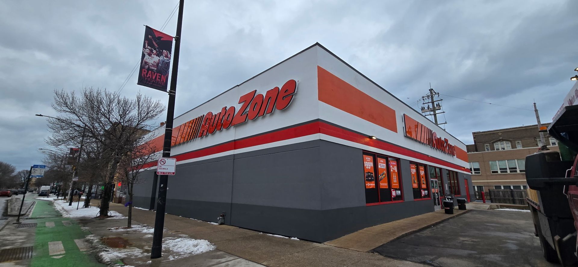 Corner view of a Popeyes restaurant with orange-and-white exterior on a cloudy street corner