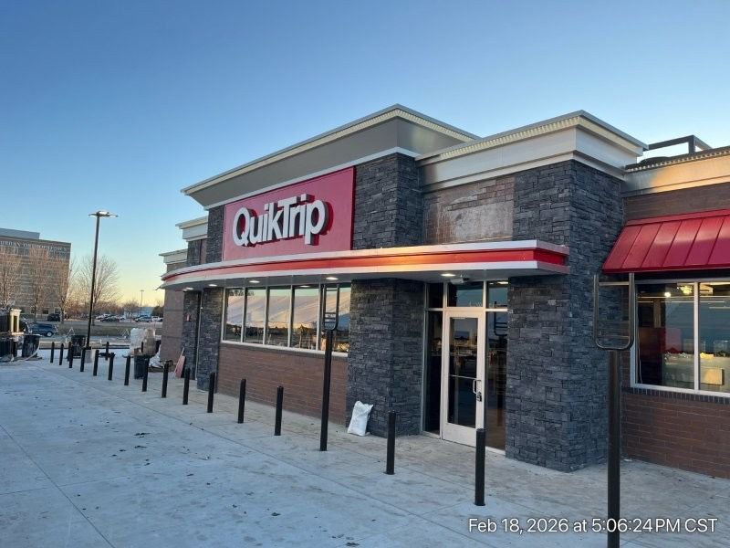 QuikTrip convenience store storefront at dusk with brick facade and red awning