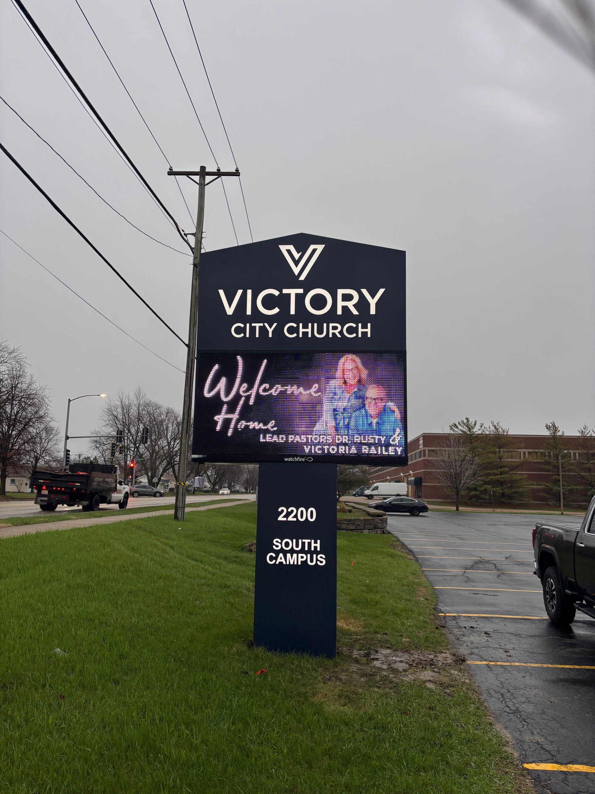 Victory City Church roadside sign with “Welcome” on a rainy roadside, 2200 South Campus.