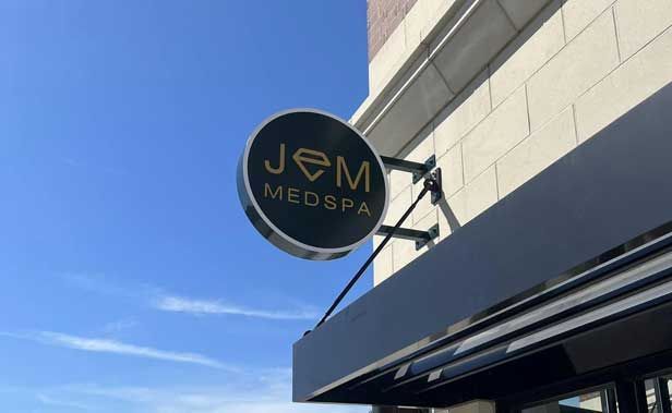 Round Medspa sign mounted on a building against a blue sky.