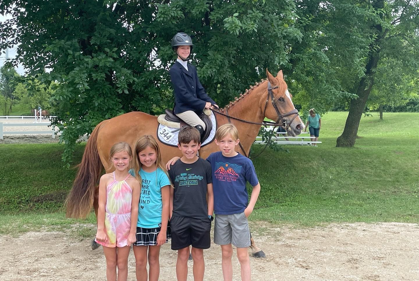 A group of children are standing next to a horse.