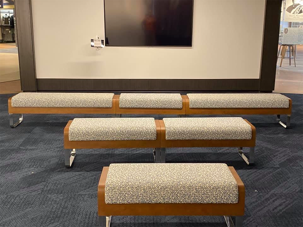 Three benches are sitting next to each other in front of a television.