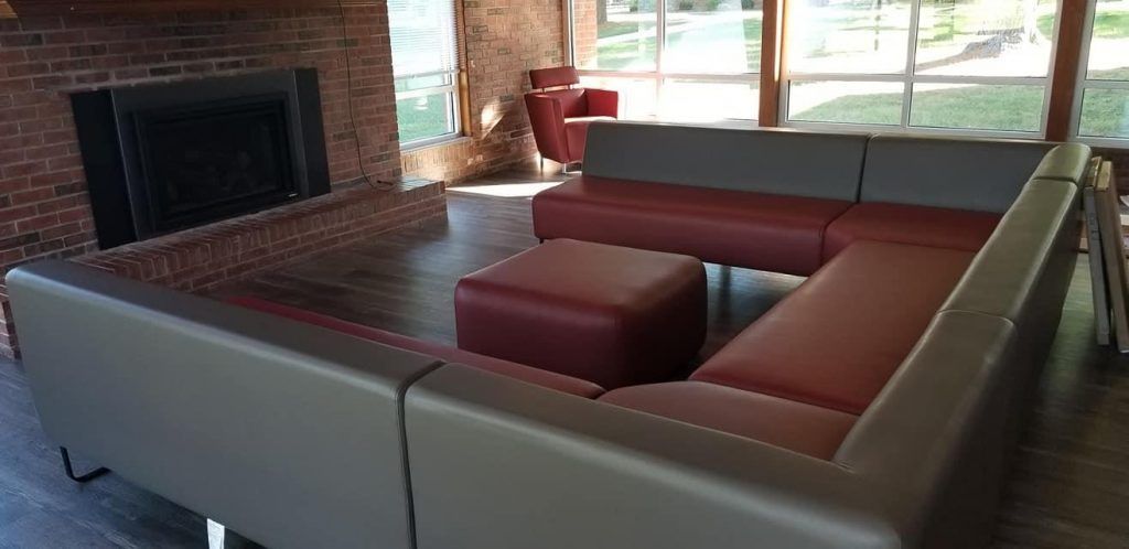 A living room with a large sectional couch and a fireplace