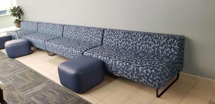A row of blue couches and ottomans in a room