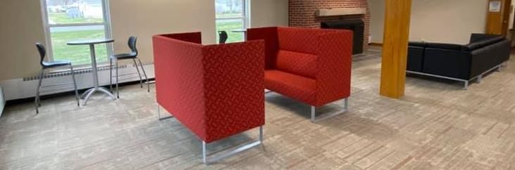 There are two red chairs in the middle of a room