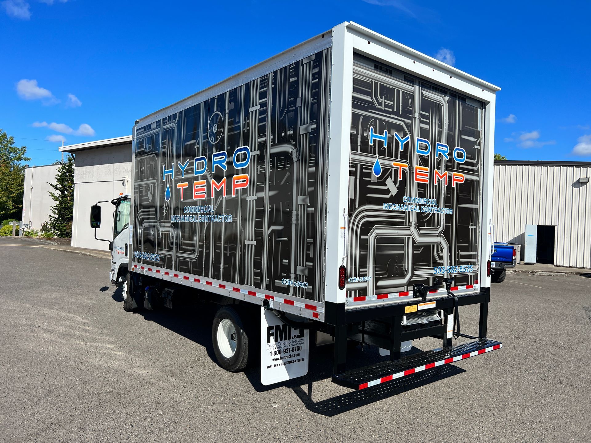 Box truck with "Hydro Systems" branding; graphic of pipes on side; blue sky.