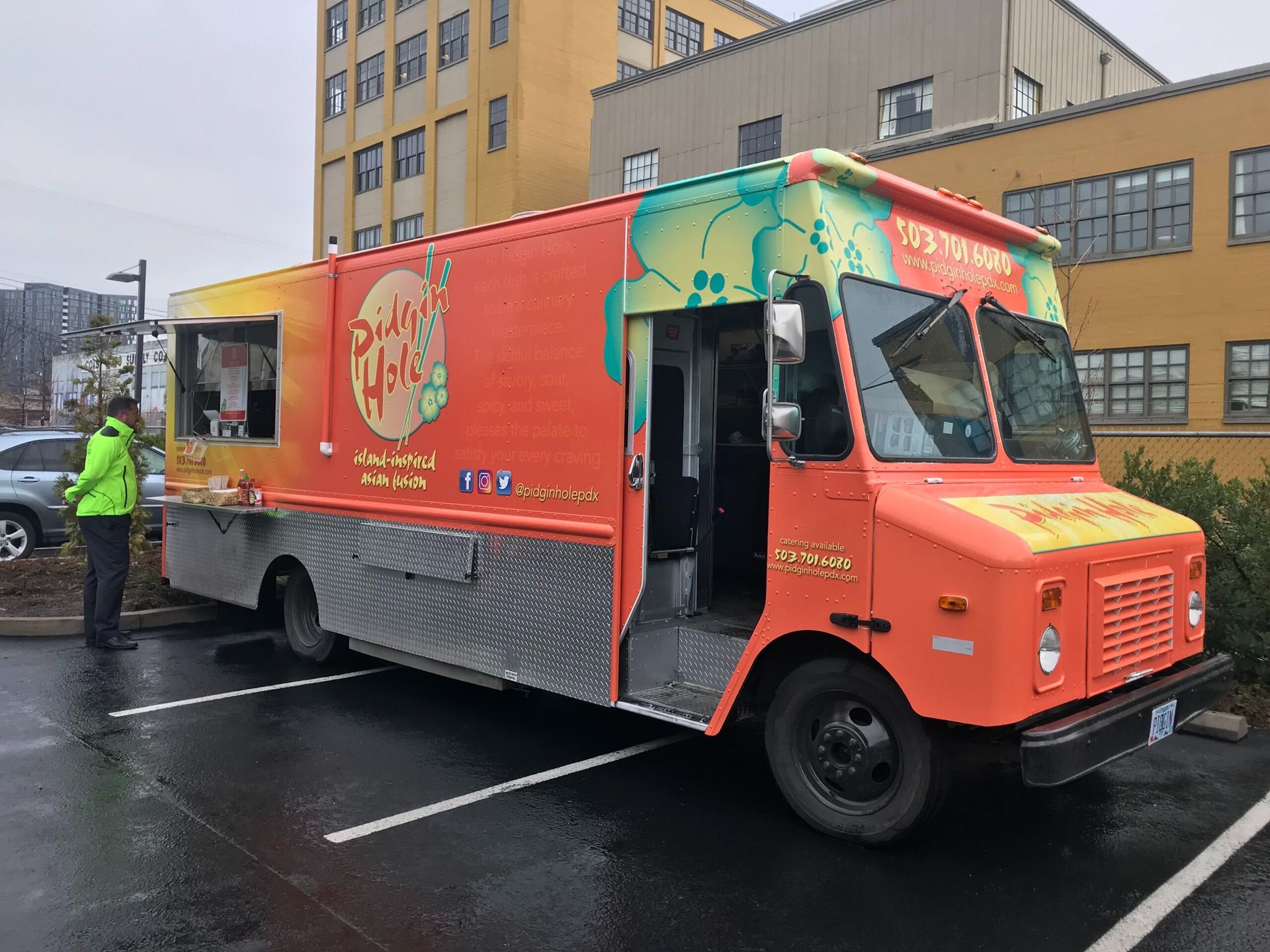 Orange Silog Yolk food truck parked in a lot, door open, with a person in a green jacket standing nearby.